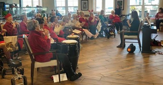 Christine Hollister, Tabitha at Prairie Commons Life Enrichment Events Coordinator, directs a performance during the “Santa’s Singalong Spectacular” event.